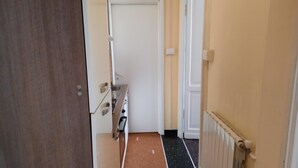 A narrow hallway with a door leading to a kitchen area. - Appartamento a Invrea Posto Auto Incluso (Genoa)