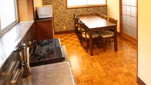 A compact kitchen with a stove, sink, and dining area. - Gran Kodachi (Fujikawaguchiko)