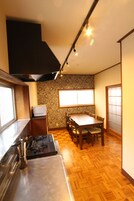 Cocina compacta con estufa, lavamanos y comedor.