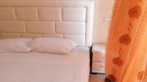 A bed with a headboard, a bedside table, and a curtain. - Residence Perle de L'Atlas 4608 (Marrakech)