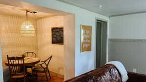 A dining area with a wooden table and chairs, a hanging light fixture, a chalkboard with writing, and a framed quote on the wall. - Steps to Lane And VT Campus Cozy 2 bed/2 bath Blacksburg Apartment (Blacksburg)