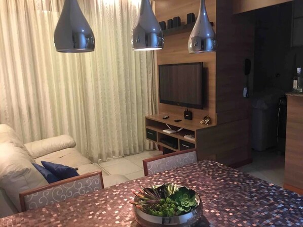 A modern living room with a dining table, sofa, and TV stand. - ⭐️ ⭐️ ⭐️ TOP - 2br, balcony, beachfront building, air conditioning, wifi, garage (Praia de Itaparica)