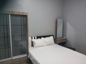 A bedroom with a bed, a nightstand, a mirror, and a sliding door. - Reno Rooms Ipoh (Ipoh)