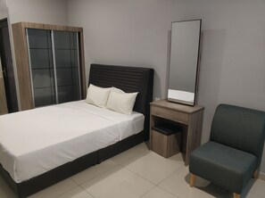 A bedroom with a bed, a wardrobe, a desk with a mirror, and a chair. - Reno Rooms Ipoh (Ipoh)
