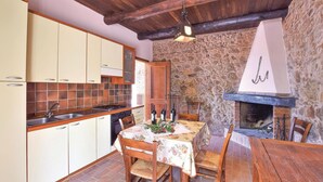 Una cocina rústica con armarios de madera, una pared de piedra y una chimenea.