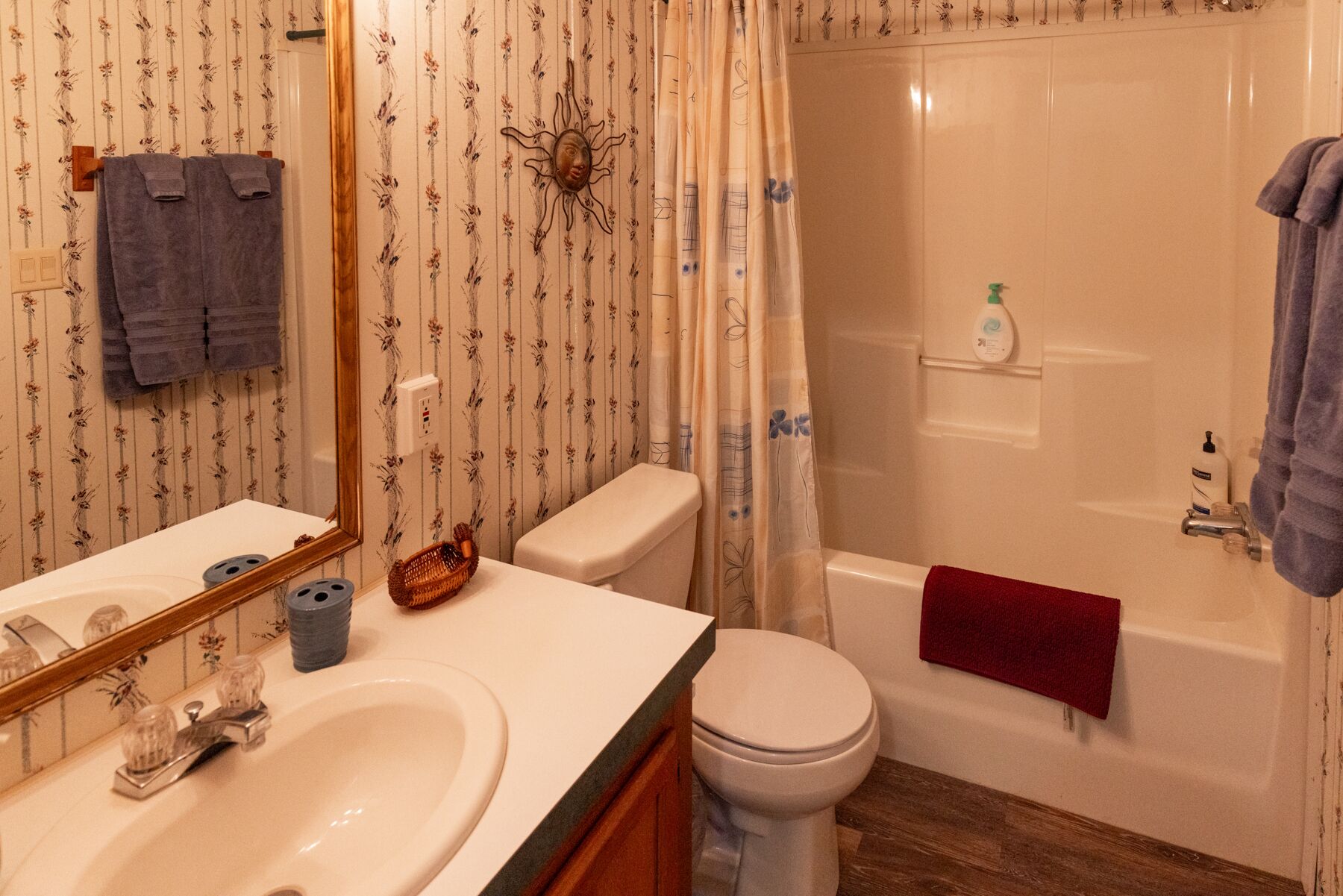 Et badeværelse med toilet, vask og badekar.