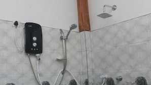 A shower area with a control panel, a handheld showerhead, and a wall-mounted showerhead. - Ruk Sewana Villa (Sigiriya)