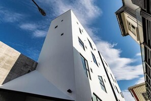 A modern building with a white facade and multiple windows.