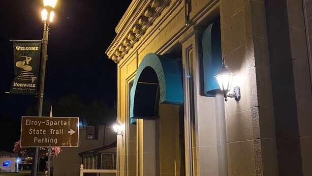 A building with a sign for Elroy-Sparta State Trail Parking. - Historic Bank Building on the Elroy-Sparta State Trail (Norwalk)
