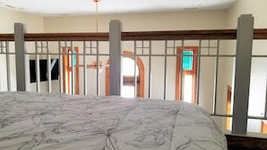 A bedroom with a bed, a TV, and a window with a view of the outside. - Historic Bank Building on the Elroy-Sparta State Trail (Norwalk)