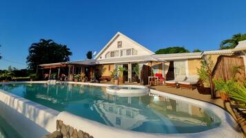 A pool area with a house in the background.