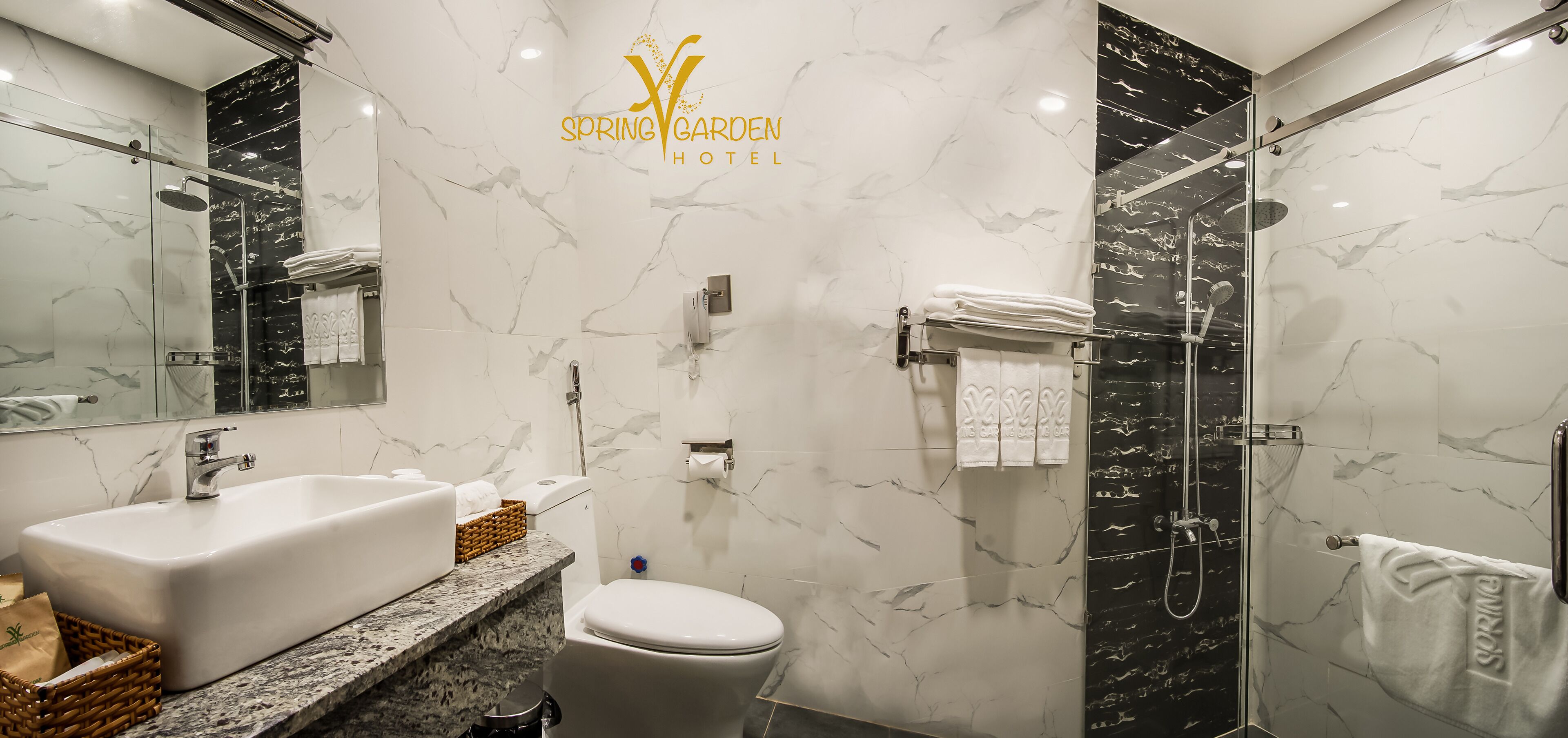 Un baño moderno con lavamanos, inodoro y ducha de mármol.