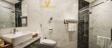Un baño moderno con lavamanos, inodoro y ducha de mármol.