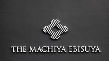 Un logo comprenant un « M » stylisé et le texte « THE MACHIYA EBISUYA ».