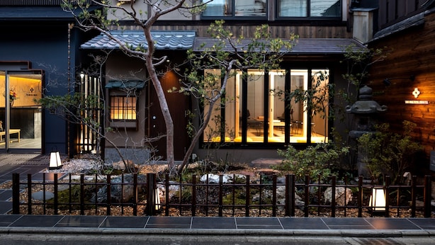 A traditional Japanese house with a wooden exterior, large windows, and a well-maintained garden. - The Machiya Ebisuya (Kyoto)