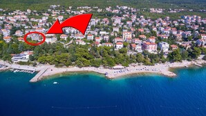 An aerial view of a coastal town with a beach, houses, and a pier. - Holiday apartment near the beach with shared hot tub (Dramalj)