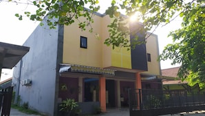 A two-story building with a flat roof, a small balcony, and a gated entrance. - OYO 2654 Yulia Guesthouse Near Kopi Bajawa Flores NTT Tebet (Jakarta)