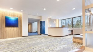 A modern reception area with a reception desk, a wall-mounted digital display, and a patterned carpet. - Wan Wan Paradise Premier Yamanakako (Yamanakako)