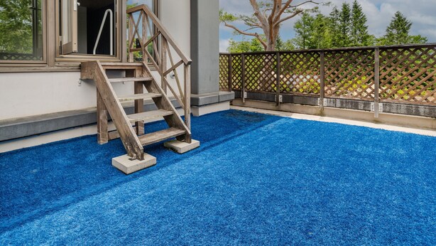 A residential property with a wooden staircase leading to a balcony, a blue artificial turf floor, and a wooden fence. - Wan Wan Paradise Premier Yamanakako (Yamanakako)