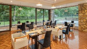 A restaurant with large windows, wooden flooring, and modern furniture. - Wan Wan Paradise Premier Yamanakako (Yamanakako)