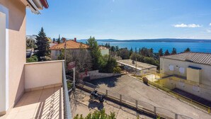 Un quartier résidentiel avec vue sur un lac, une moto garée et un bâtiment doté d’un toit en tuiles.