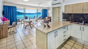 Una cocina moderna con una isla central, un comedor con vistas y un balcón panorámico.
