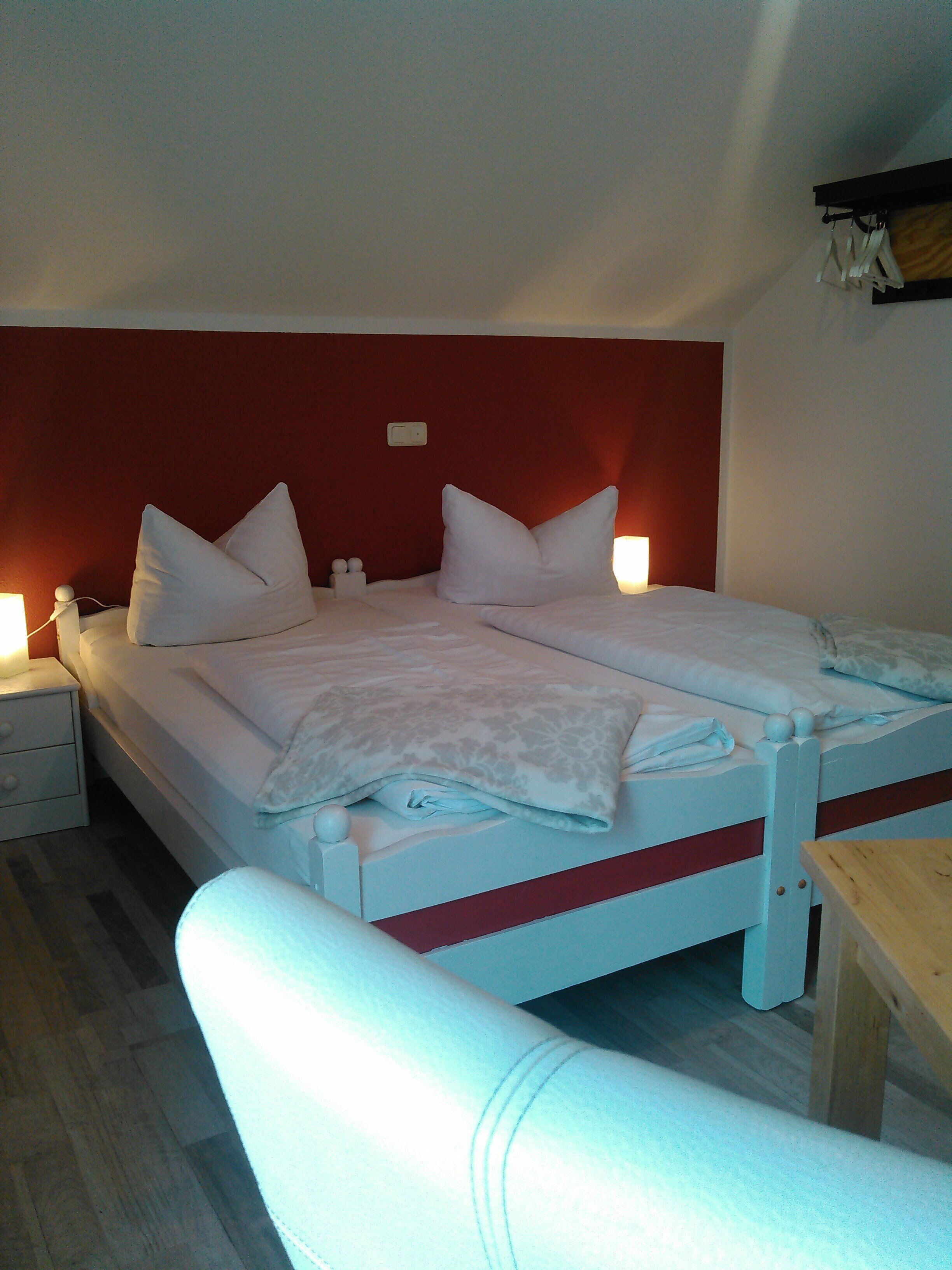 A bed with two pillows, a bedside table, and a nightstand.