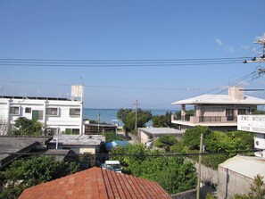 Zona residencial con edificios, cielo despejado y vista al mar.