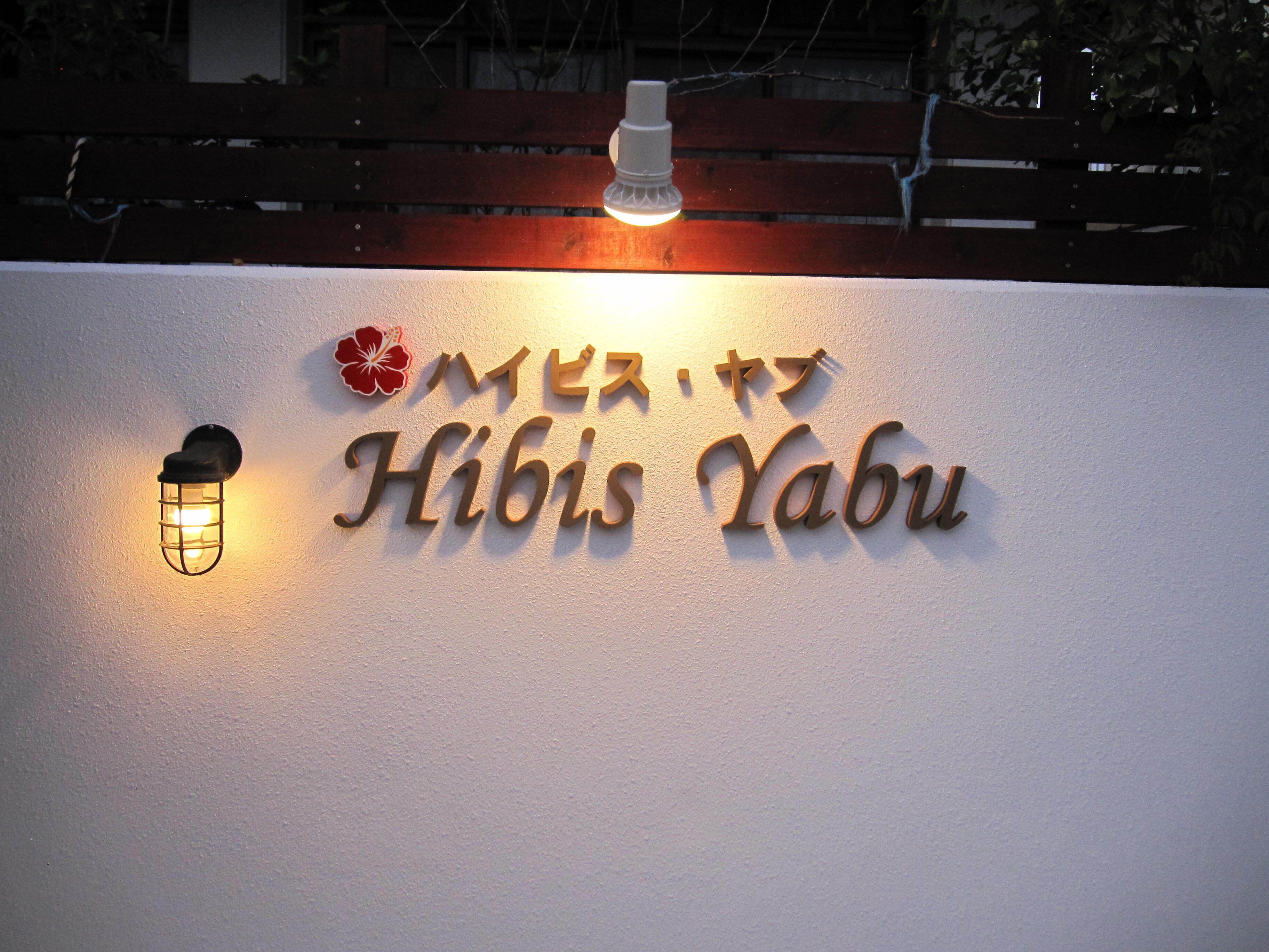 A sign with the name "Hibus Yabu" and a hibiscus flower logo.