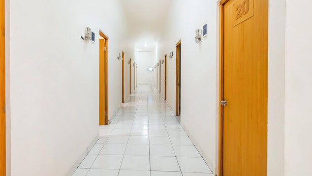 A hotel corridor with wooden doors, each marked with a number. - Hotel O Syariah Tasikmalaya Near Universitas Siliwangi Formerly Siliwangi Guest House (Tasikmalaya)