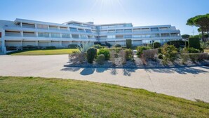 A modern multi-story hotel with a central courtyard and a clear sky. - Résidence du Golfe by Interhome (Port Camargue)