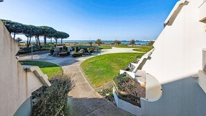 A modern building with a curved balcony, a landscaped garden, and a view of the sea. - Résidence du Golfe by Interhome (Port Camargue)