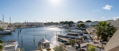 A marina with boats docked, a clear sky, and a sunny day.