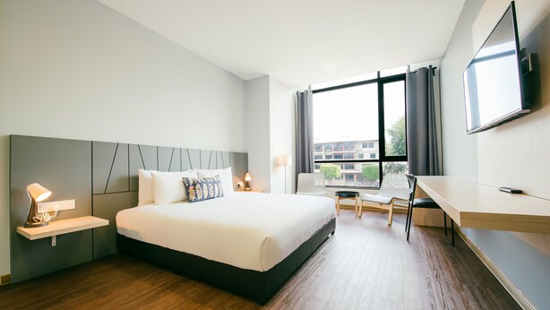 A modern hotel room with a large bed, a desk, and a TV. - Signature by The Concept (Langkawi)