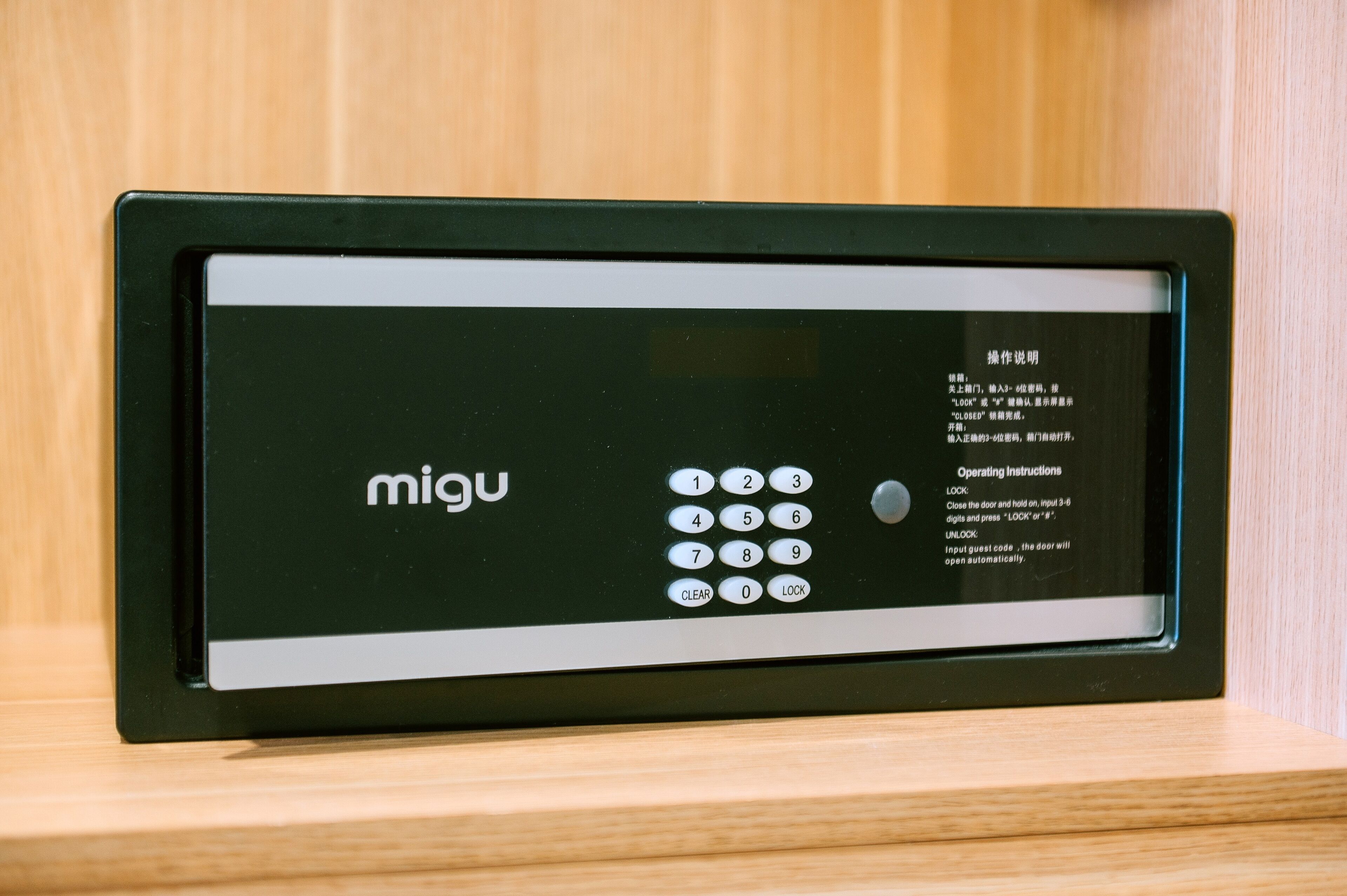 A black electronic device with a keypad and operating instructions in multiple languages.