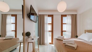 A hotel room with two beds, a desk, a TV, and large windows with curtains. - Villa Oriens in Gennadi (Rhodes)