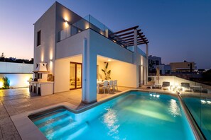 A modern house with a swimming pool, outdoor seating, and a pergola. - Villa Oriens in Gennadi (Rhodes)