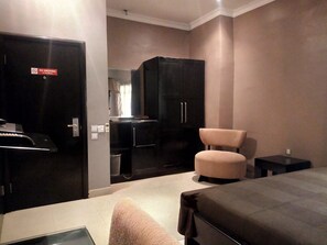 Hotelkamer met een bed, een tafeltje, een stoel, een kast en een rookvrij bordje.
