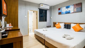 Une chambre d’hôtel avec deux lits, un bureau, une salle de bain et un tableau au mur.