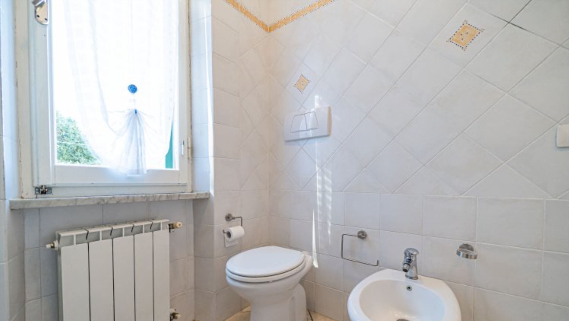 Een badkamer met toilet, bidet en wastafel.
