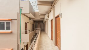 A corridor with a patterned floor, a staircase, and multiple doors.