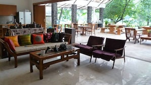 A spacious indoor area with a sofa set, wooden chairs, and a dining table. - Ronia Mountain Villa Lembang (Lembang)