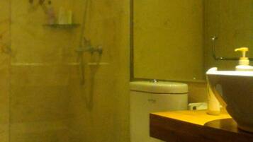 A small bathroom with a toilet, a sink, and a shower.