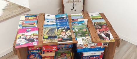 Une table en bois, sur laquelle on trouve divers jeux de société et des livres.