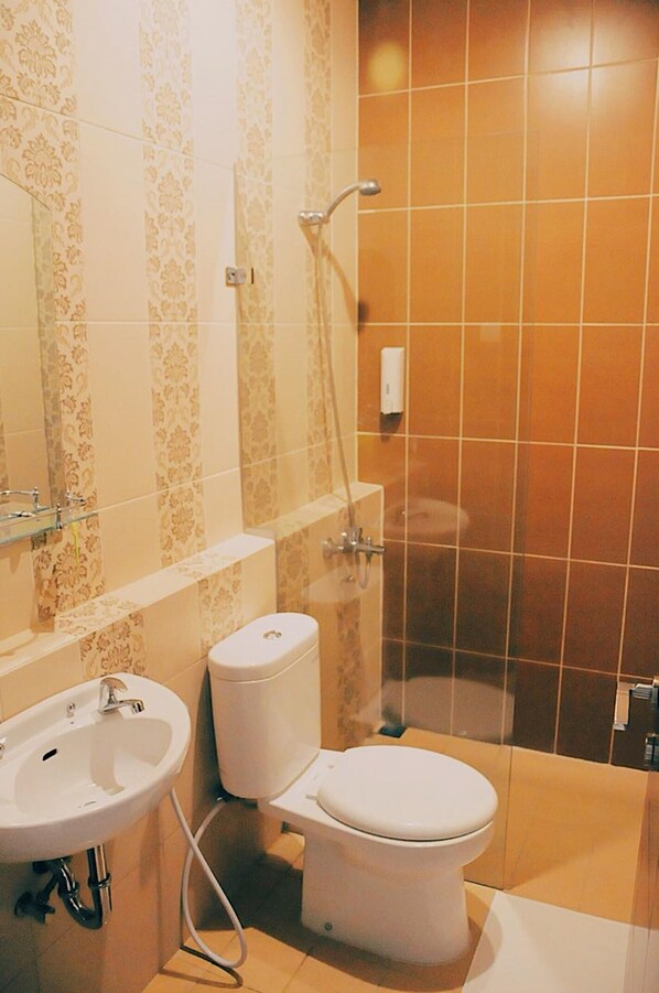 A bathroom with a toilet, sink, and shower.