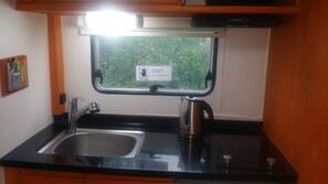 Standaard stacaravan | Privékitchenette | Een koelkast, een magnetron, een kookplaat, een waterkoker
