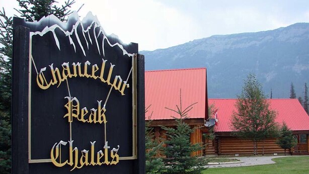 Indicador per als xalets 'Chanelot Peak Chalets' amb un paisatge de muntanyes al fons.