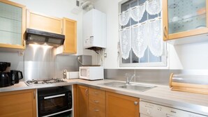 A compact kitchen with a gas stove, microwave, oven, and dishwasher.