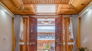 Una habitación con cama, cortinas y vistas a un edificio tradicional.
