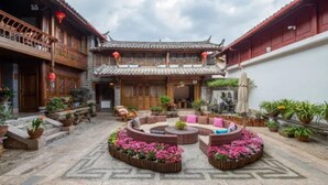 Un patio con arquitectura tradicional, un espacio central para sentarse y plantas en macetas.